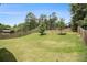 Large, grassy backyard with a wooden privacy fence and mature trees, offering ample space at 6213 Old Kingston Dr, Atlanta, GA 30331