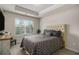 Comfortable bedroom boasts a tufted headboard, tray ceiling, and large window with natural light at 6213 Old Kingston Dr, Atlanta, GA 30331
