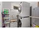 Efficient laundry area features a stacked washer and dryer and shelving for supplies at 1148 Ne Hardee Ne St, Atlanta, GA 30307