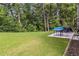 The backyard features a lush green lawn, a patio, and is bordered by trees and shrubs at 1469 Cliff View Ter, Conyers, GA 30012