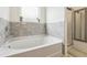 Bright bathroom featuring a soaking tub with marble tile and a glass-enclosed shower at 1469 Cliff View Ter, Conyers, GA 30012