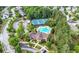 Aerial view of a community including a pool, tennis court, clubhouse, parking, and tree-lined streets at 6403 Queens Court Trce, Mableton, GA 30126