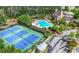 Aerial view showcasing the tennis courts, pool, clubhouse, and surrounding landscape of the community at 6403 Queens Court Trce, Mableton, GA 30126