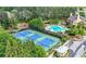 Aerial view of tennis courts, pool, clubhouse, and lush greenery creating a beautiful community setting at 6403 Queens Court Trce, Mableton, GA 30126