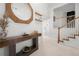 Bright entryway featuring wood accents, decorative mirror, stylish table, and stairs to the upper level at 6403 Queens Court Trce, Mableton, GA 30126