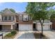 Beautiful brick townhome featuring a two-car garage and lovely front yard landscaping at 6403 Queens Court Trce, Mableton, GA 30126