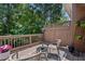 Cozy patio area with wooden deck, chairs, rug and privacy fence surrounded by lush green trees at 6403 Queens Court Trce, Mableton, GA 30126