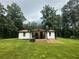 Charming, cottage-style home featuring a welcoming front porch and lush green lawn at 241 Wooten Ct, Canton, GA 30114