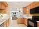 Well-lit kitchen featuring wooden cabinets, white countertops, and black appliances, seamlessly flowing into the adjacent living area at 3268 Clairmont North Ne Rd, Brookhaven, GA 30329