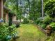 A lush green backyard featuring flowering plants, lawn, and a retaining wall at 350 Fountain Oaks Ln, Atlanta, GA 30342