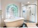 Luxurious bathroom featuring a standalone tub, walk-in shower, and an arched window at 350 Fountain Oaks Ln, Atlanta, GA 30342
