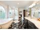 Bright bathroom with a glass shower, soaking tub, marble countertops, and an arched window at 350 Fountain Oaks Ln, Atlanta, GA 30342