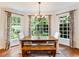 Sunny dining area with wooden table, bench, and picturesque views through large windows at 350 Fountain Oaks Ln, Atlanta, GA 30342