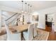 Bright dining area with a wooden table, upholstered chairs, pendant lighting, and a view of the staircase at 350 Fountain Oaks Ln, Atlanta, GA 30342