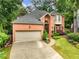 Charming two-story brick home featuring an attached two-car garage and meticulously manicured landscaping at 350 Fountain Oaks Ln, Atlanta, GA 30342