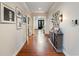 Long hallway with hardwood floors, decorative artwork, and a view of the entry with black double doors at 350 Fountain Oaks Ln, Atlanta, GA 30342
