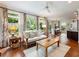 Open-concept living room with hardwood floors, large windows, and a dining area at 350 Fountain Oaks Ln, Atlanta, GA 30342
