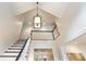 Elegant staircase with a black handrail and white spindles, ascending to a second-story landing with a light fixture at 350 Fountain Oaks Ln, Atlanta, GA 30342