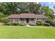 Traditional home boasts a lush green lawn, landscaping and inviting covered porch at 621 Windgrove Se Dr, Marietta, GA 30067