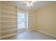 View of a bedroom with custom built-in shelving on two walls, a window, and light-colored wood-look floors at 1102 Wynnes Ridge Se Cir, Marietta, GA 30067
