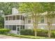 Two story home featuring neutral siding, a screened in porch, and roof chimney and manicured shrubs at 1102 Wynnes Ridge Se Cir, Marietta, GA 30067