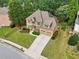 Aerial view of a home with a manicured lawn, two-car garage, and mature trees surrounding the property at 3595 Millwater Xing, Dacula, GA 30019