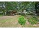 Large backyard with mature trees, green lawn, and a wooden swing set, perfect for outdoor relaxation at 3595 Millwater Xing, Dacula, GA 30019