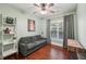 Charming bedroom featuring hardwood floors, large windows, a ceiling fan and a seating area with a couch at 3595 Millwater Xing, Dacula, GA 30019