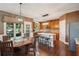 Kitchen area with stainless steel appliances, wooden cabinets, light countertops and large wooden table set at 3595 Millwater Xing, Dacula, GA 30019