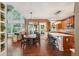 Open concept kitchen area with light countertops, wooden cabinets and table, alongside large windows and living area at 3595 Millwater Xing, Dacula, GA 30019