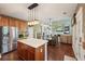Spacious kitchen and dining area with wooden cabinets, stainless steel appliances, and an open layout to living area at 3595 Millwater Xing, Dacula, GA 30019