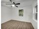 A bright bedroom featuring light, hard surface floors, a ceiling fan, and two windows at 4670 Brookwood Dr, Cumming, GA 30041