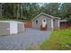 A side view of the home with a detached garage, gravel parking area and grass at 4670 Brookwood Dr, Cumming, GA 30041