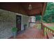 Covered porch featuring a welcoming entrance with decorative plants, bench, and a detailed brick wall at 4670 Brookwood Dr, Cumming, GA 30041