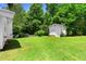 Spacious backyard featuring a storage shed, green lawn, and privacy provided by mature trees at 501 Samaritan Dr, Cumming, GA 30040