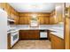 Traditional kitchen with wood cabinets, white appliances, and tile flooring at 501 Samaritan Dr, Cumming, GA 30040