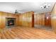Cozy living room featuring a stone fireplace, wood paneling, and hardwood floors at 501 Samaritan Dr, Cumming, GA 30040