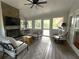 A relaxing sunroom featuring a stone fireplace, natural light, and comfortable seating arrangements at 747 Dogwood Cir, Norcross, GA 30071