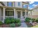 Inviting front porch with white columns, brick accents, and lush landscaping. Perfect for relaxing outdoors at 4520 Odum Lake Trl, Cumming, GA 30040