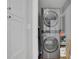 Convenient laundry area with stacked washer and dryer and shelving, providing ample storage at 4520 Odum Lake Trl, Cumming, GA 30040