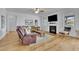 Cozy living room with hardwood floors, a fireplace, a TV, and comfortable seating at 4520 Odum Lake Trl, Cumming, GA 30040