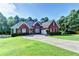 Charming single-story brick home with a well-manicured lawn and a long driveway leading to an attached garage at 2068 Tribble View Way, Lawrenceville, GA 30045