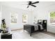 Well-lit bedroom featuring windows, a ceiling fan, and a bed with patterned pillows at 2086 Harold Se Ave, Smyrna, GA 30080