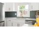 Contemporary kitchen featuring stainless steel appliances, white cabinets, and a window offering natural light at 2086 Harold Se Ave, Smyrna, GA 30080