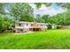 Expansive backyard featuring a deck, lush lawn, and mature trees, perfect for outdoor living and entertaining at 3156 Laurel Way, Snellville, GA 30078