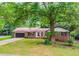 Inviting single-story home with brick exterior, a well-maintained lawn, and mature trees providing ample shade at 3156 Laurel Way, Snellville, GA 30078