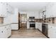Galley kitchen with white cabinets, stainless steel appliances, and wood backsplash at 3156 Laurel Way, Snellville, GA 30078