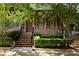 Charming brick townhome featuring a well-maintained lawn, stairs leading to the front door, and mature trees at 345 Glen Iris Ne Dr # 5, Atlanta, GA 30312
