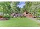 Attractive front exterior featuring a manicured lawn, mature trees, and an attached 2-car garage at 4920 Tremont Ne Dr, Marietta, GA 30066