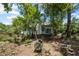 View of backyard with home visible through the trees, and an old hose reel in the grass at 881 Mclinden Se Ave, Smyrna, GA 30080